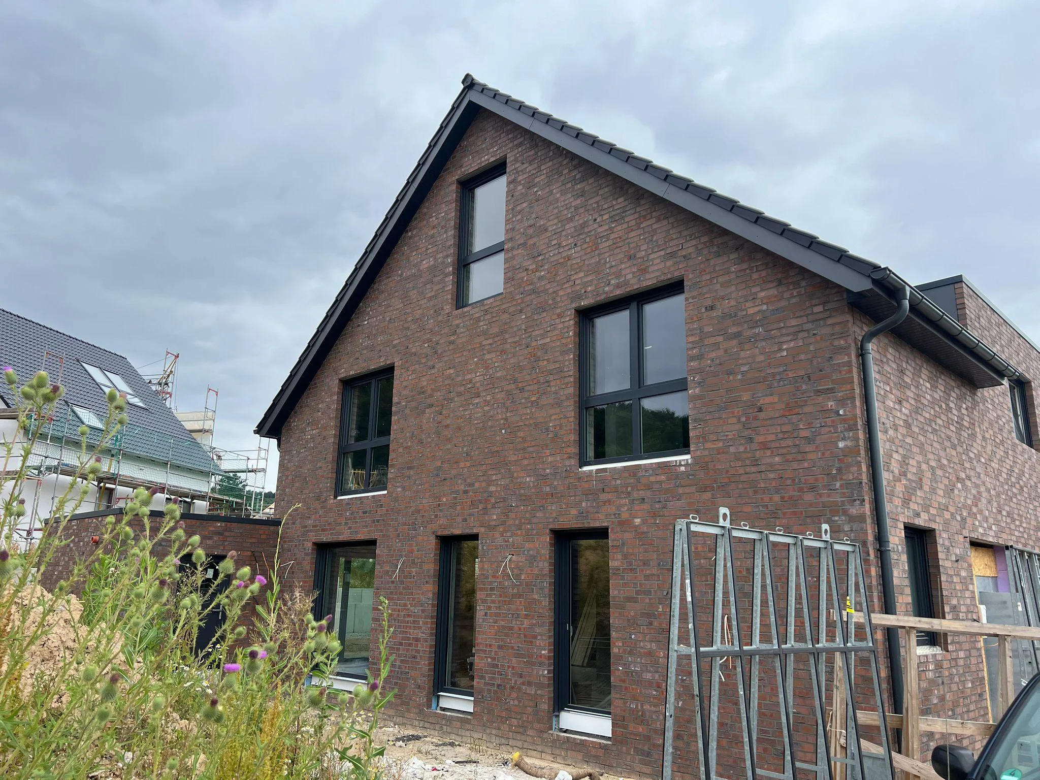 Fenster und Terrassentüren an einem verklinkerten Neubau – Seitenansicht