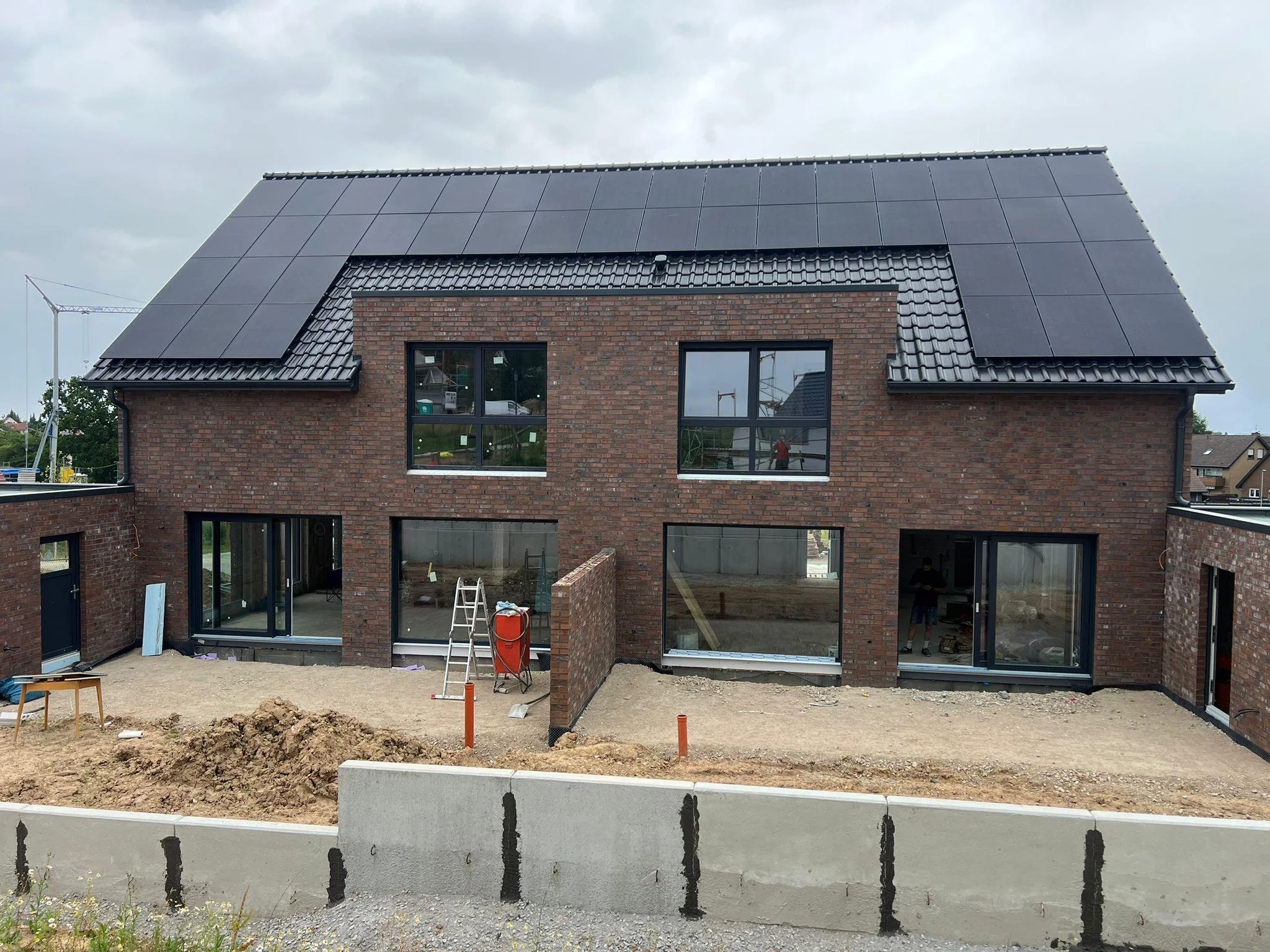 Großformatige Fenster und Terrassentüren mit Solaranlage – Rückansicht